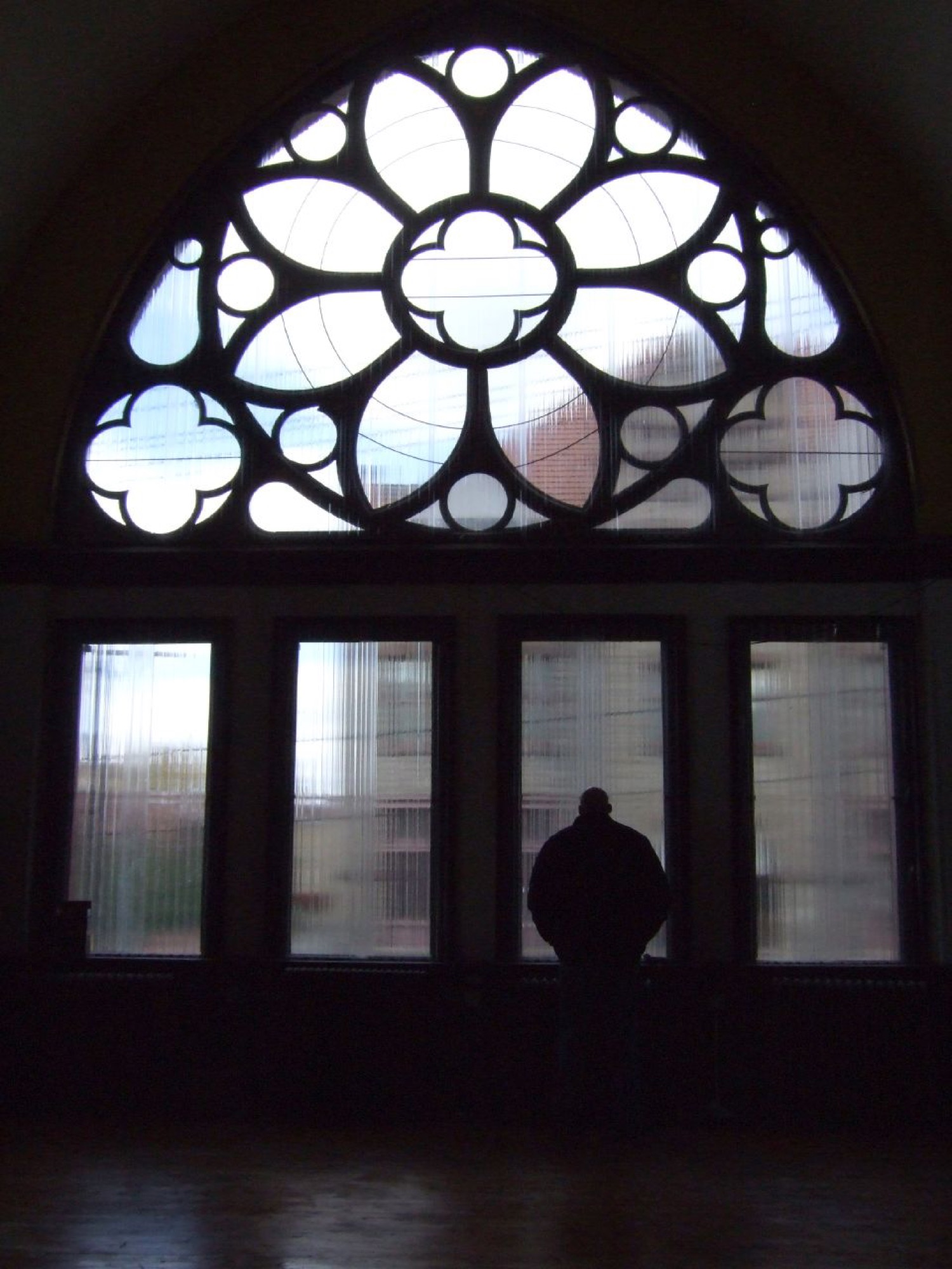 A tall man silhouetted in the window of a derelict church in Braddock, 2006.