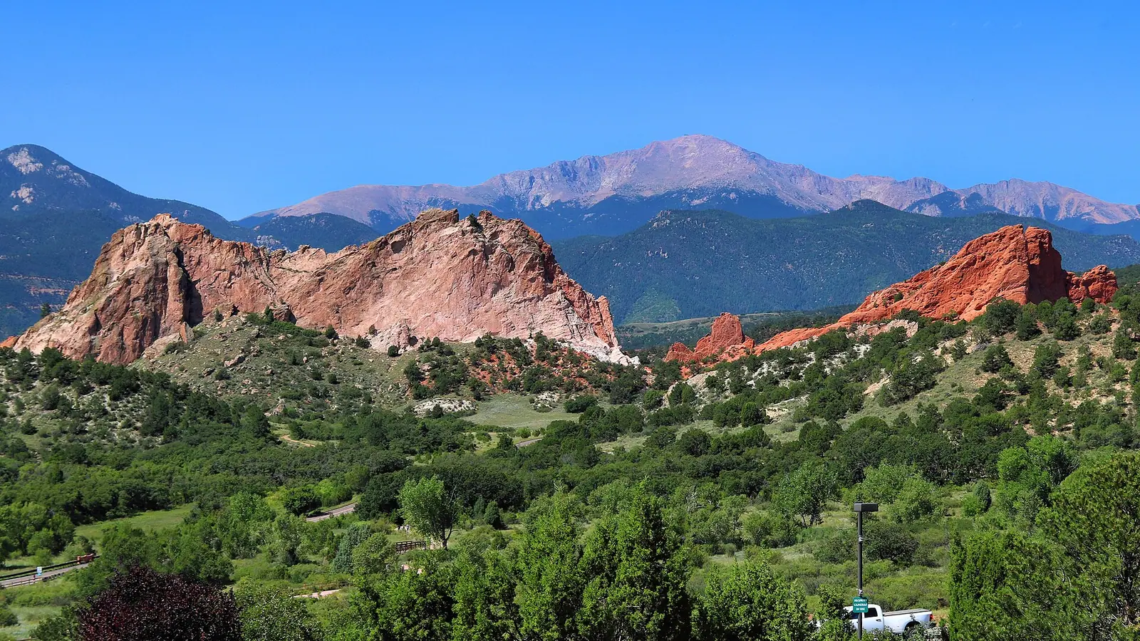 The red sandstone formations of the Garden of the Gods, with Pikes Peak rising behind them.